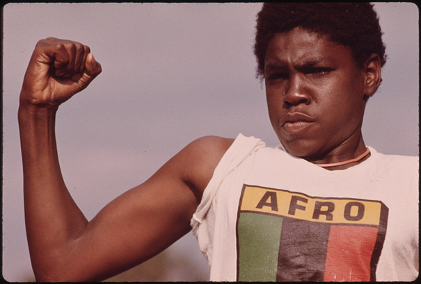 A Young Black Man Showing His Muscle during a Small Community Program in Chicago on the South Side, 08/1973